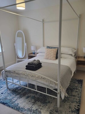 Relax in comfort with a four-poster bed, complete with a large round mirror and bedside tables.