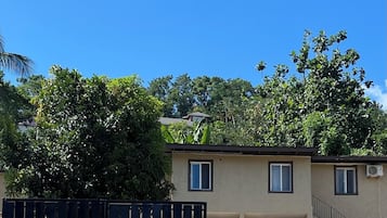 A residential building with a beige exterior, a black metal gate, and a clear blue sky.