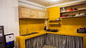A compact kitchen with a yellow countertop, a built-in sink, and wooden cabinets.