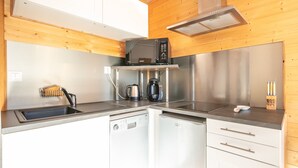 Una cocina compacta equipada con microondas, cafetera y lavavajillas.