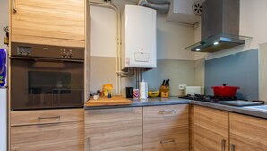 A modern kitchen with wooden cabinets, a Bosch oven, a water heater, and a gas stove.
