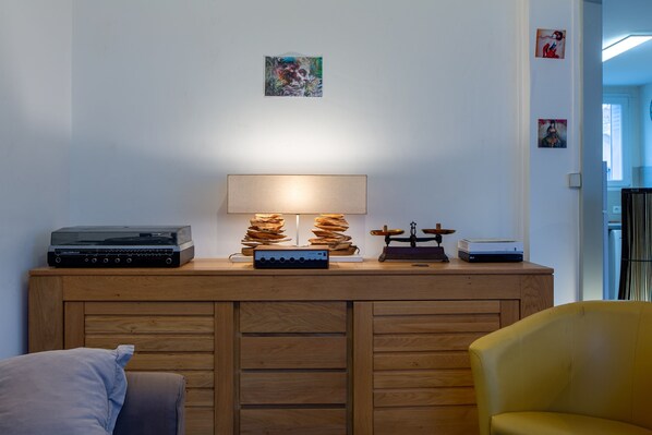 Una habitación con un armario de madera, una lámpara y un tocadiscos.