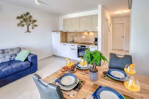 A modern apartment with a dining area, kitchenette, and a living room. - Holiday apartment with sea view (Njivice)