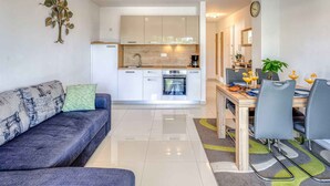 A modern kitchen with white cabinets, a built-in oven, and a coffee maker. - Holiday apartment with sea view (Njivice)