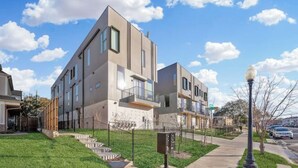 Un moderno edificio de apartamentos con techo plano, ventanas amplias y un césped bien cuidado.