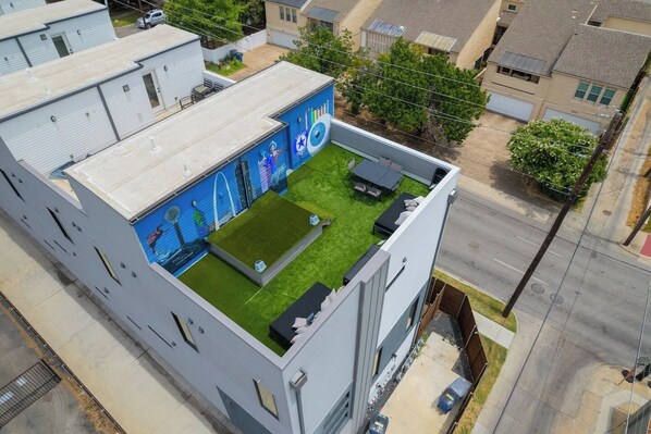 A multi-story building with a rooftop garden, a mural, and a parking area. - Modern & Spacious~Rooftop View of Downtown Dallas (Dallas)