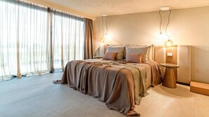 Une chambre moderne avec un grand lit, une table de chevet et une lampe fixée au mur.