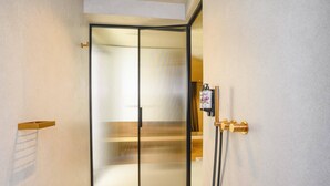 Une salle de bain moderne avec une douche à parois de verre, un porte-serviettes et un distributeur de savon fixé au mur.