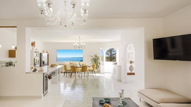 A modern living room with a sofa, a coffee table, and a TV mounted on the wall. - Villa Blu Marino by Villa Plus (Syracuse)