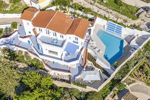 Un edificio grande de varios pisos con piscina y zonas de estar al aire libre.