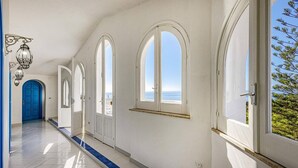 A corridor with arched windows and a view of the sea. - Villa Blu Marino by Villa Plus (Syracuse)