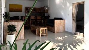 Uma sala de estar moderna com um sofá de madeira, uma mesa de centro e uma televisão. Há um armário de madeira e uma planta no canto.