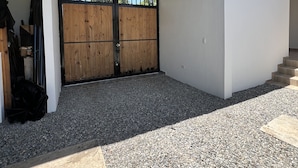 A modern building with a wooden gate, gravel ground, and a clear sky. - Beautiful country house in San Martin (pet and family friendly) (San Martín)