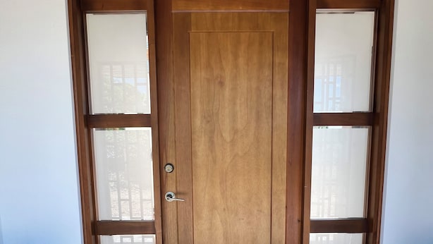 A wooden door with a glass panel, a tiled floor, and two black stools. - Beautiful country house in San Martin (pet and family friendly) (San Martín)