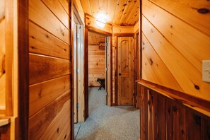 Ein Holzbodenkorridor mit Teppichboden und einer Tür am Ende.