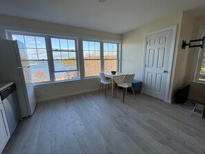 A kitchen with a view of a lake, a dining table with chairs, and a white door.