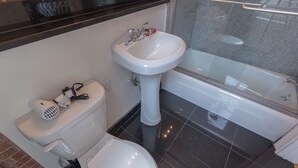 A bathroom with a toilet, bidet, and bathtub.