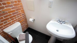 A small bathroom with a toilet, a sink, and a roll of toilet paper on the wall. - Chic STUDIO with WiFi near Empire State Building (New York)