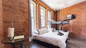 A room with a bunk bed, a glass table with toiletries, and a brick wall. - Chic STUDIO with WiFi near Empire State Building (New York)