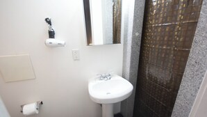 A bathroom with a white sink, a mirror, a towel dispenser, and a toilet paper holder. - Chic STUDIO with WiFi near Empire State Building (New York)