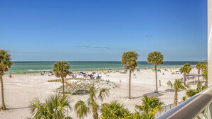 A beach with palm trees, sun loungers, and umbrellas. - Beachfront Luxury with Spectacular Gulf Views: Residence 303 (Siesta Key)