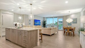 A modern kitchen with a central island, pendant lighting, and a view to the outdoors. - Perfect for a More Intimate Getaway: Residence 408 (Siesta Key)