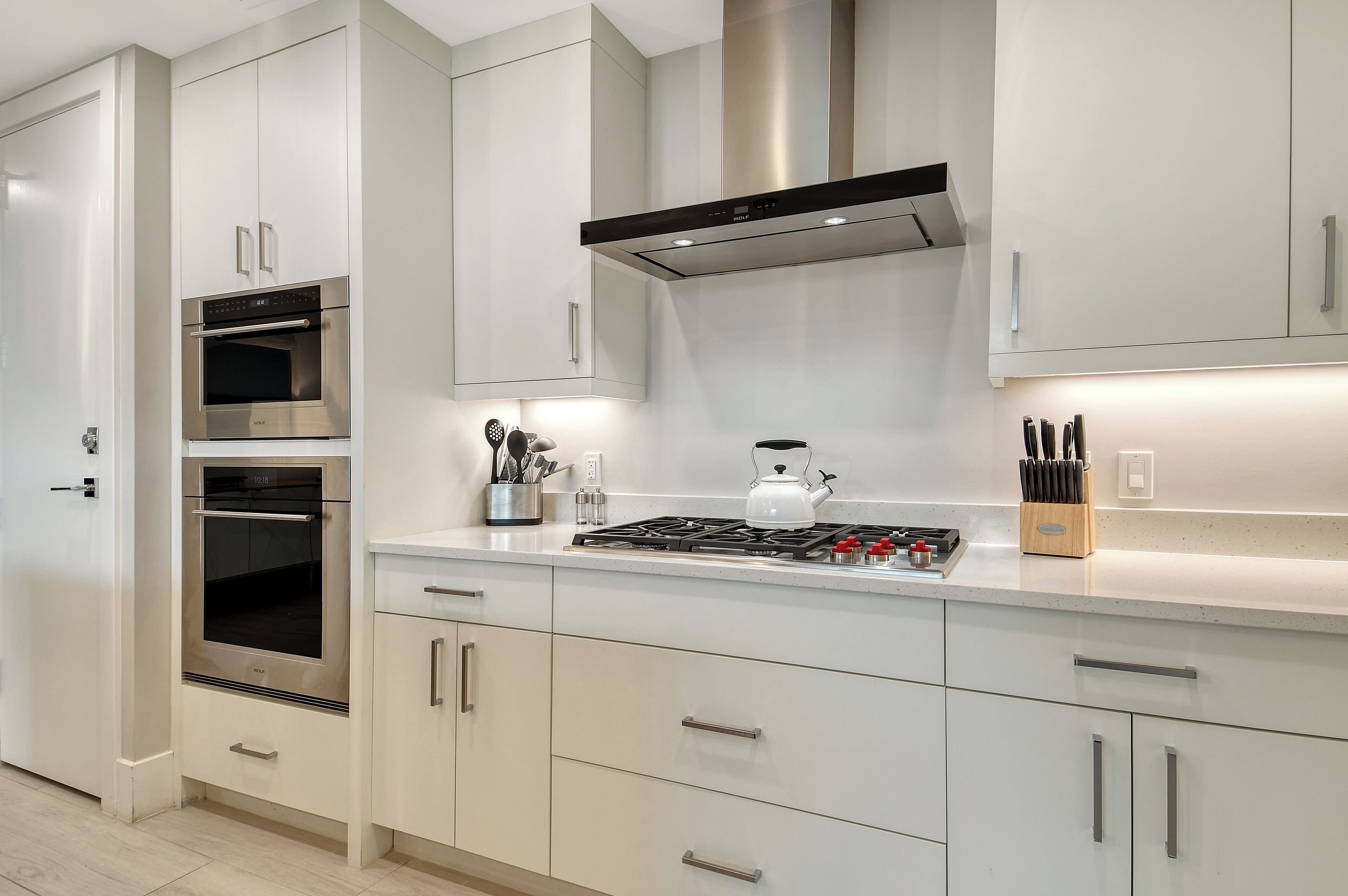 Een moderne keuken met roestvrijstalen apparatuur, een gasfornuis en witte kasten.