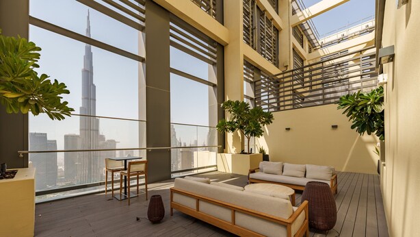 Una terrazza panoramica moderna con divani, poltrone e piante in vaso.