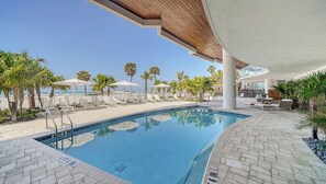 A pool area with lounge chairs, umbrellas, and palm trees. - Stunning 4 Bedroom Rental W/ Oversized Terrace & Big Beach Views: Residence 506 (Siesta Key)