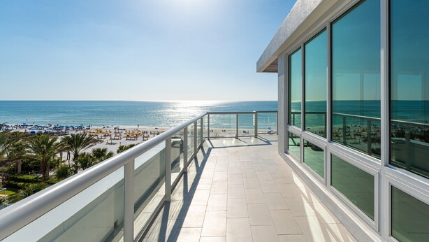 Ein Balkon mit Blick auf Strand und Meer.