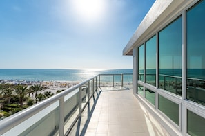Un balcon avec vue sur la plage et l’océan.