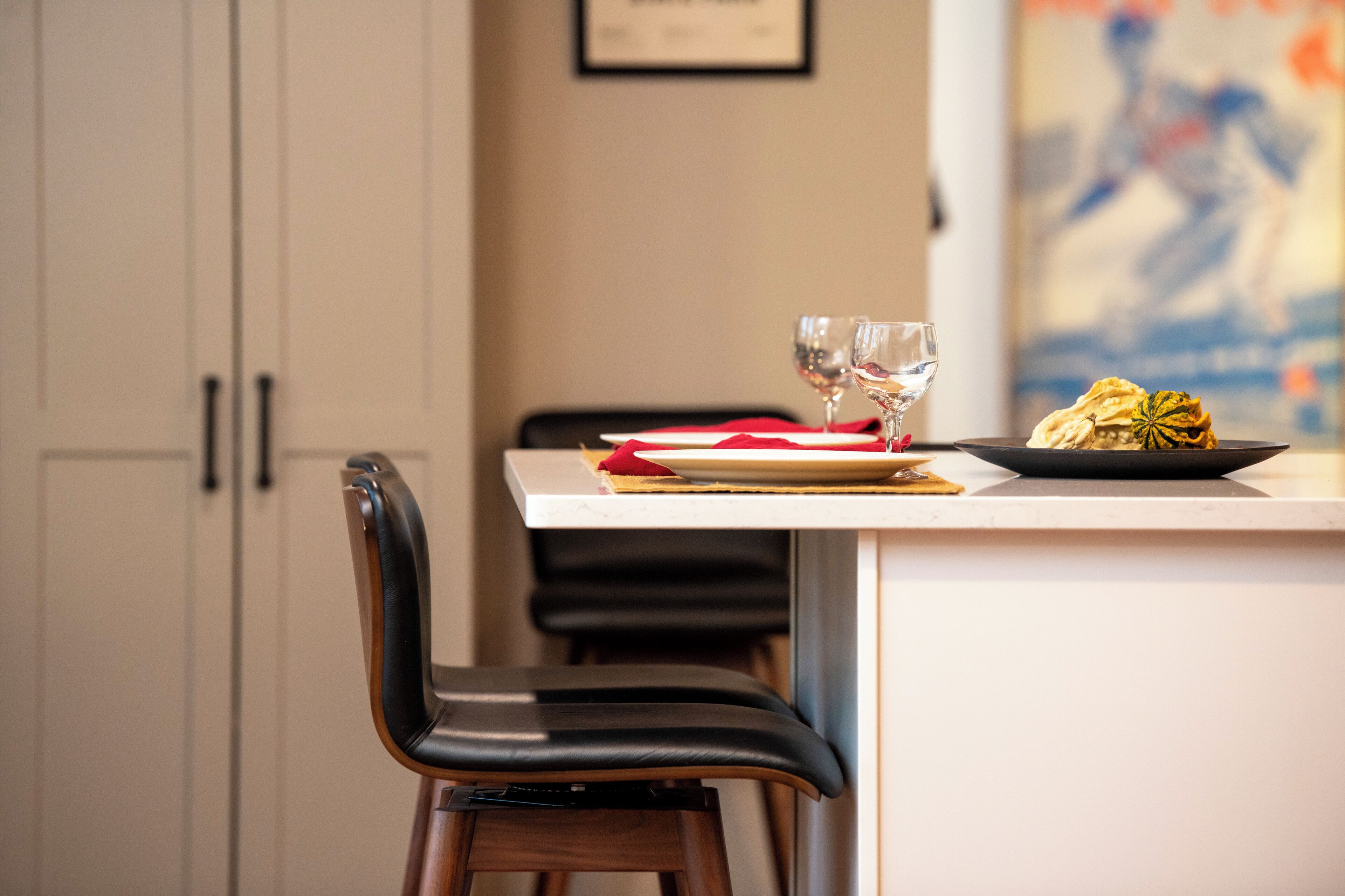Een eethoek met een tafel gedekt voor twee personen, inclusief een bord eten en twee glaasjes water.
