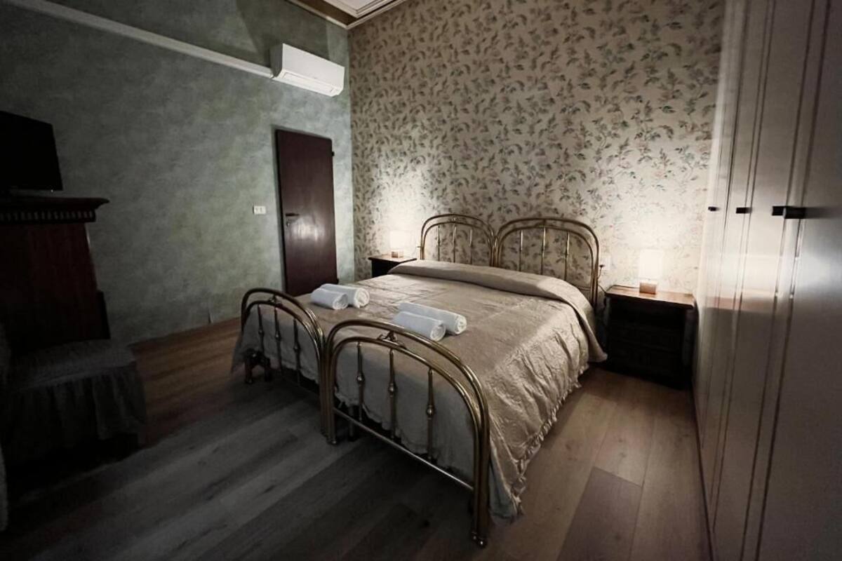 Un dormitorio con cama doble, armario de madera y mesita de noche con lámpara.
