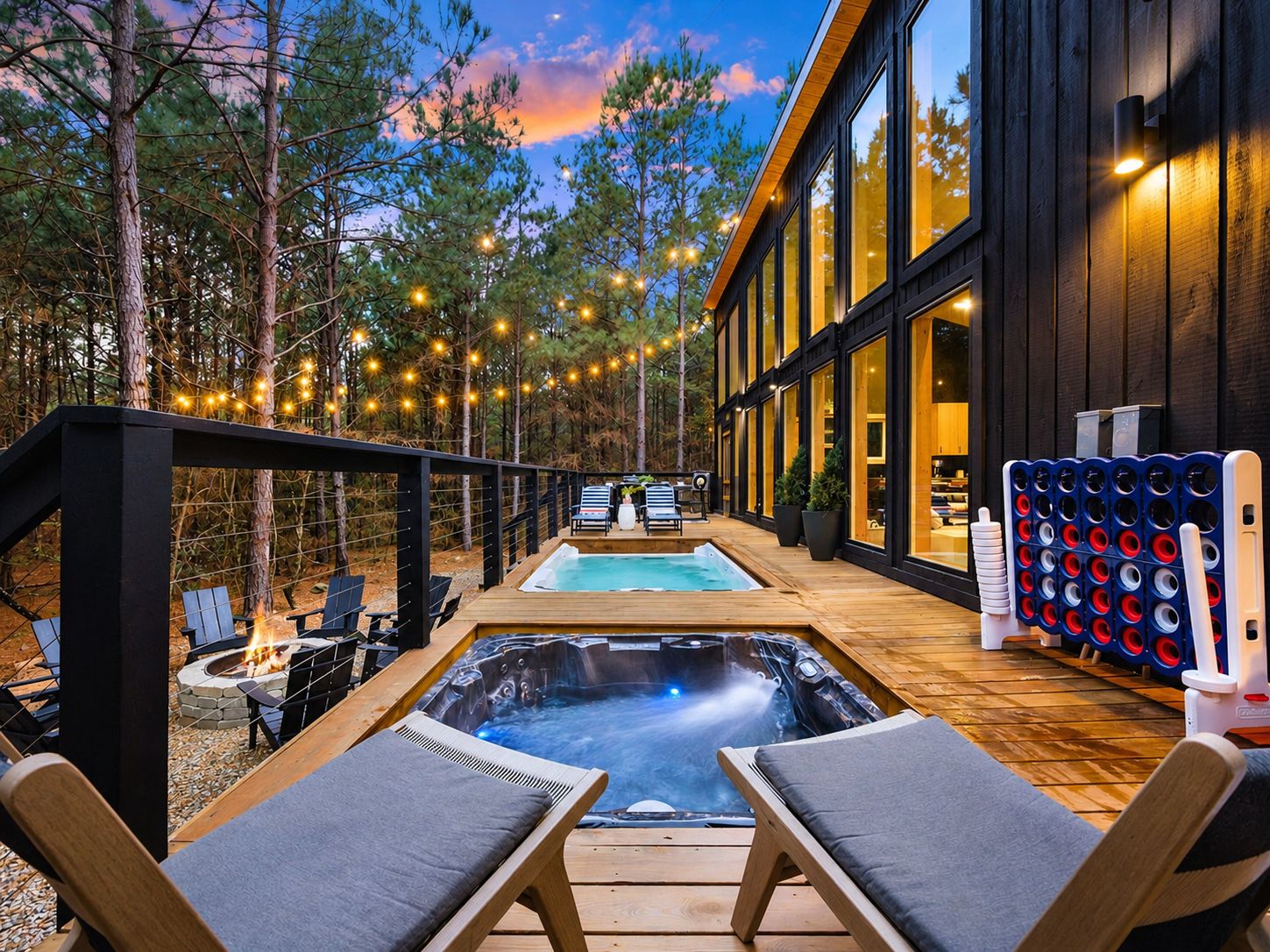 A modern outdoor hot tub area with lounge chairs, a pool, and string lights.