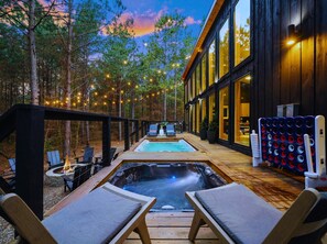 A modern outdoor spa area with a hot tub, lounge chairs, and a pool, surrounded by trees and string lights. - Swim & Play | Heated Pool Spa | PoolTbl/Ping Pong (Broken Bow)