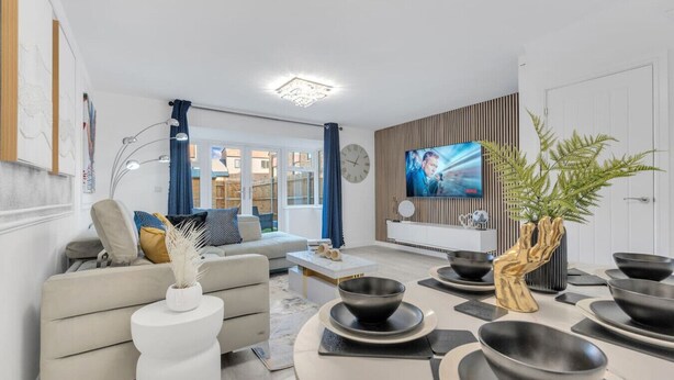 Una sala de estar moderna con un sofá, una mesa de centro y un televisor montado en la pared.