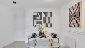 Un comedor con una mesa de mármol, sillas doradas y decoración en blanco y negro.