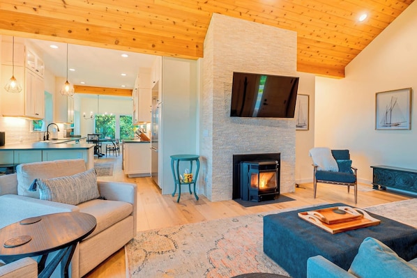 A modern living room with a fireplace, a sofa, a coffee table, and a television mounted on the wall.
