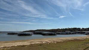 A marina with several covered docks and a grassy shoreline.