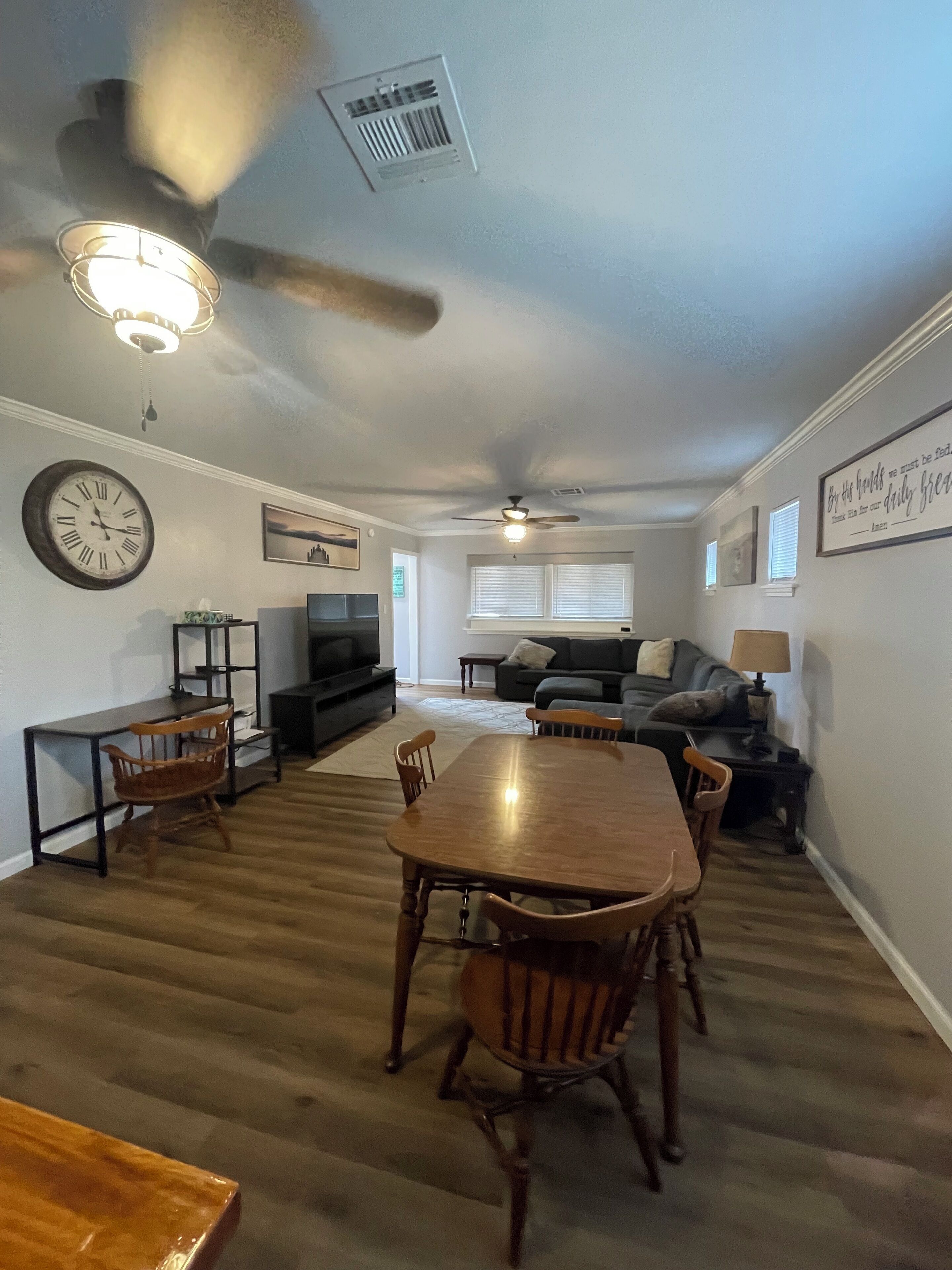 Un salón amplio con mesa de comedor, sillas, sofá y televisor.