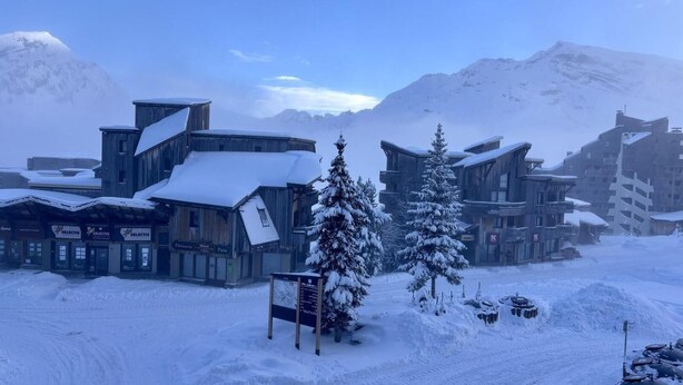 Un pueblo nevado en la montaña con edificios de madera, incluyendo un restaurante llamado 'Selectis'.