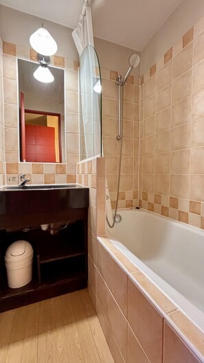 A bathroom with a bathtub, a glass shower enclosure, a vanity with a mirror, and a toilet. - 10m from ski slopes, 2nd floor, view resort, balcony, tv, ski locker, 24m², Avoriaz (Avoriaz)