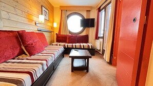Una habitación acogedora con una cama grande, un banco y una pequeña mesa.