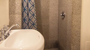 Un baño con ducha, lavabo e inodoro.