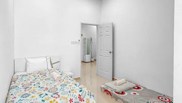 Una camera da letto con un letto, un comodino, una sedia, un armadio e una porta che dà su un'altra stanza.