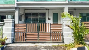 A two-story residential building with a balcony on the upper floor, a gated entrance, and a small garden area. - 4 Bedroom Landed House (Batu Pahat)