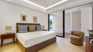 A modern bedroom with a large bed, bedside tables, a chair, and a view through a glass door.
