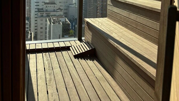 A high-rise building with a wooden deck and a city view.