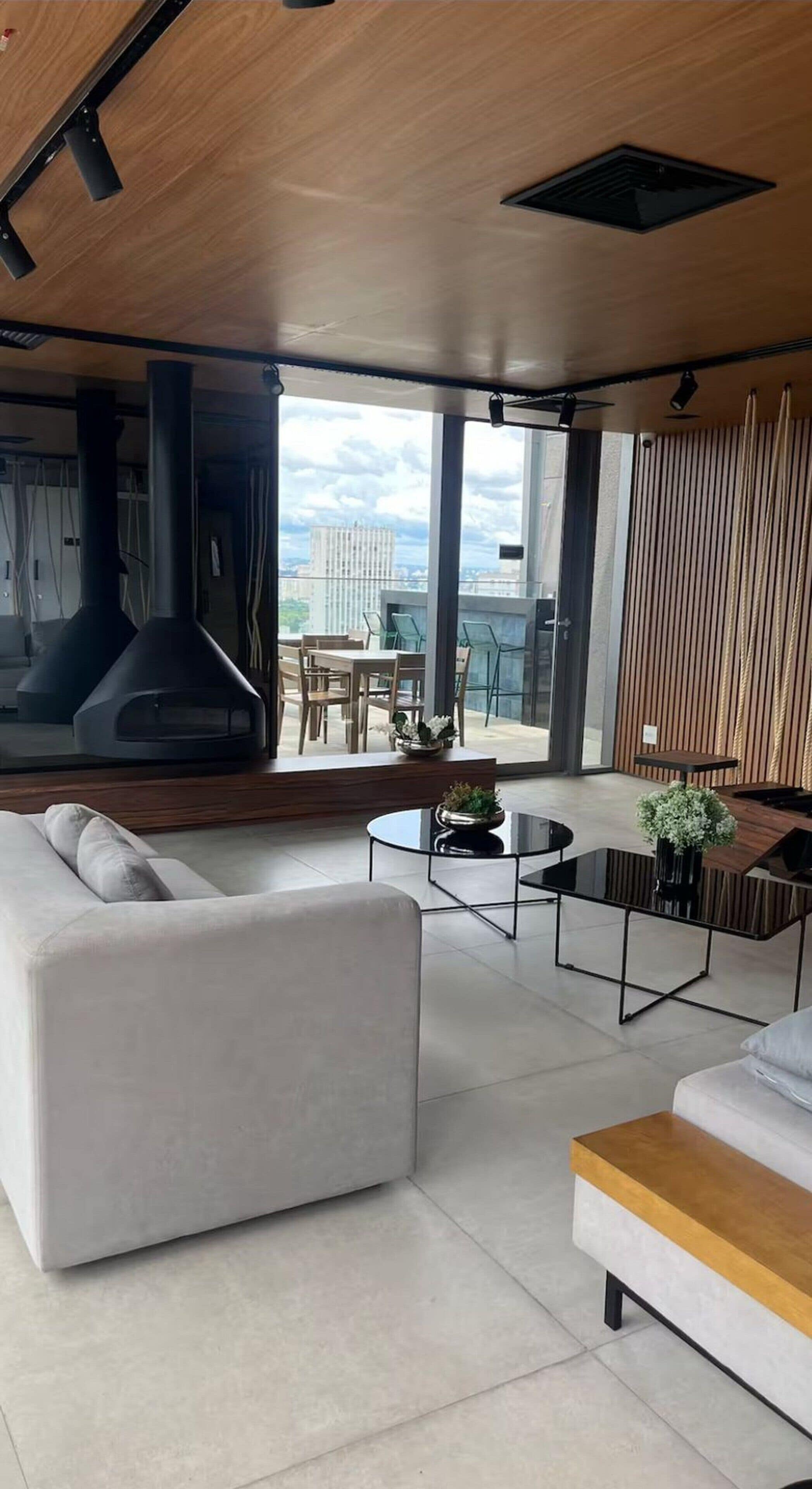 Un salon moderne avec un canapé, une table basse et une vue sur l’extérieur.