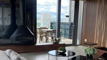 Un salon moderne avec un canapé, une table basse et une vue sur l’extérieur.